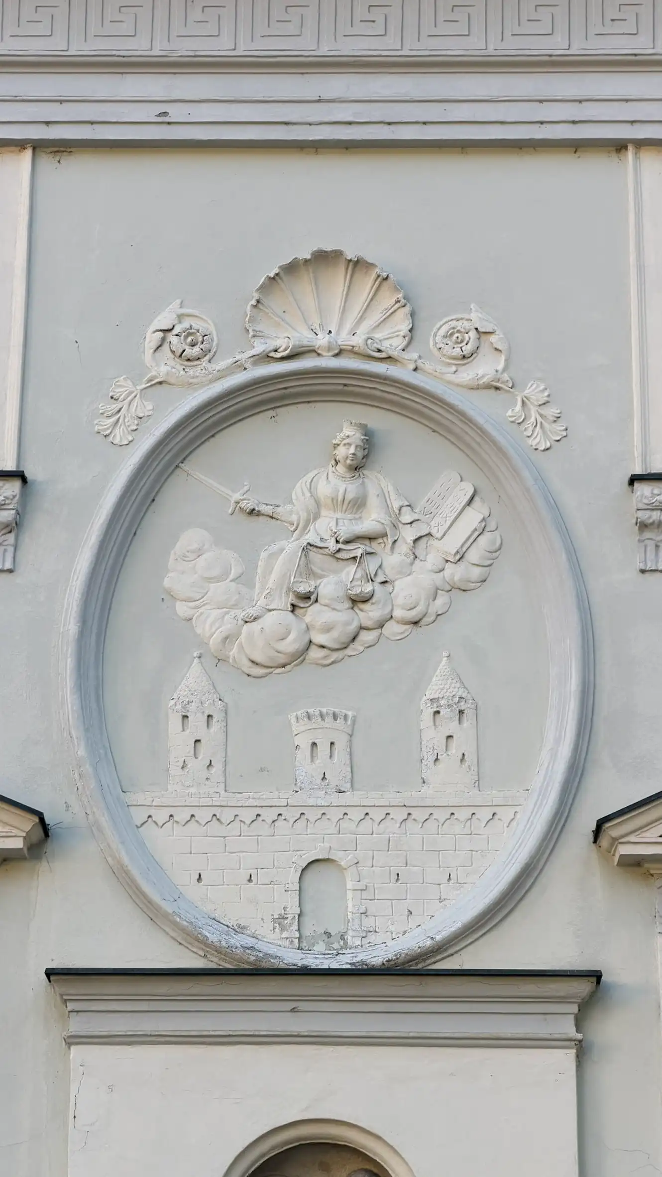 Stucco relief depicting Justitia and the coat of arms of Friesach, set within an oval frame