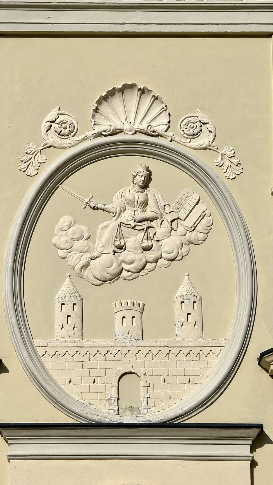 Stuckrelief mit Justitia und dem Wappen der Stadt Friesach, im ovalen Rahmen