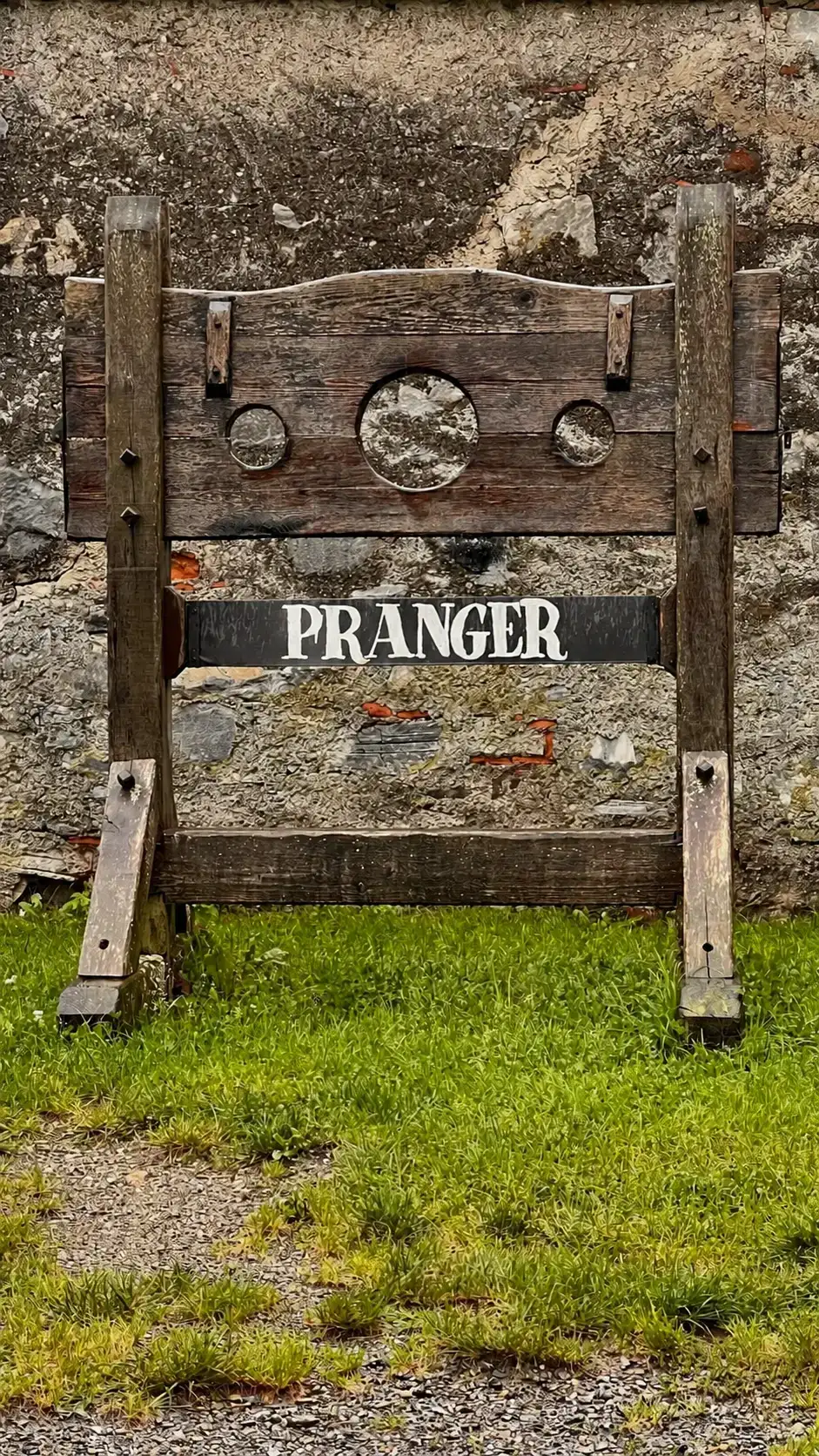 The three holes of a pillory: central hole for the neck, two side holes for the wrists