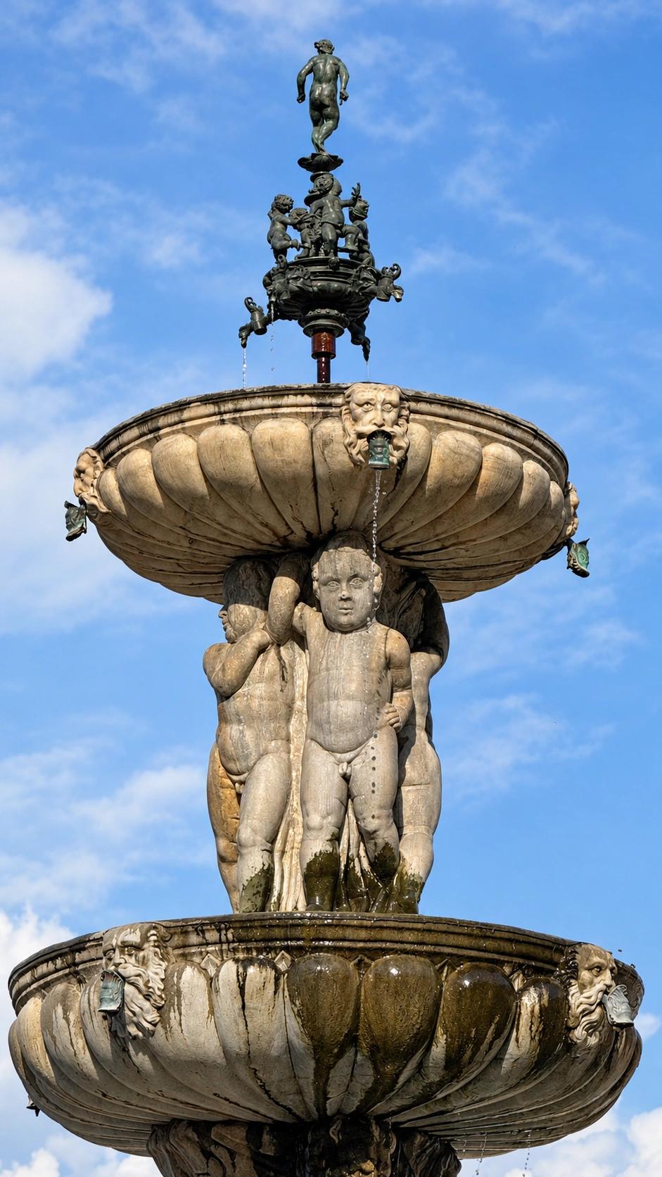 Four putti-like figures and the bronze group at the top